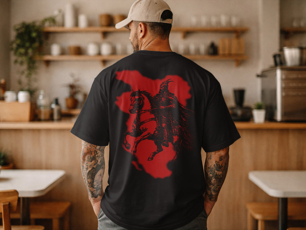 Person wearing a black t-shirt with a red and black graphic design in a kitchen setting